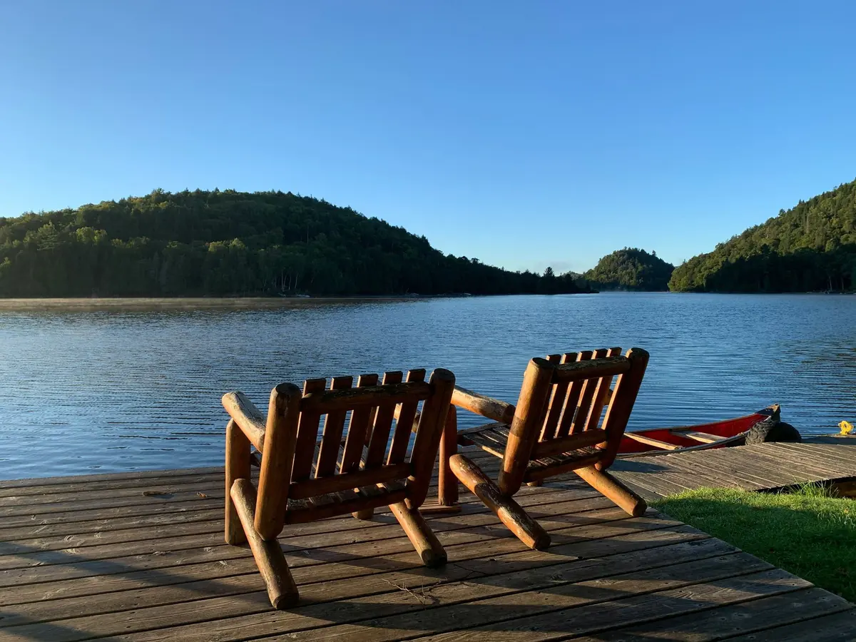 Wooden chairs on a dock overlooking a peaceful lake - Moving to Lake Norman guide